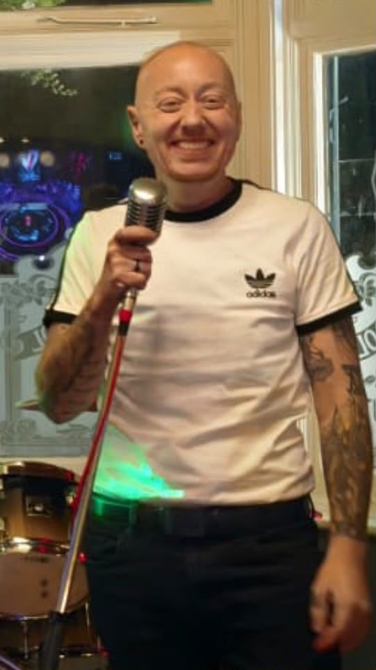 Albie holding a microphone before a performance